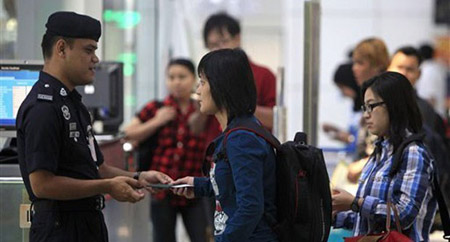 Kiểm tra giấy tờ của người nhập cư tại sân bay Kuala Lumpur.